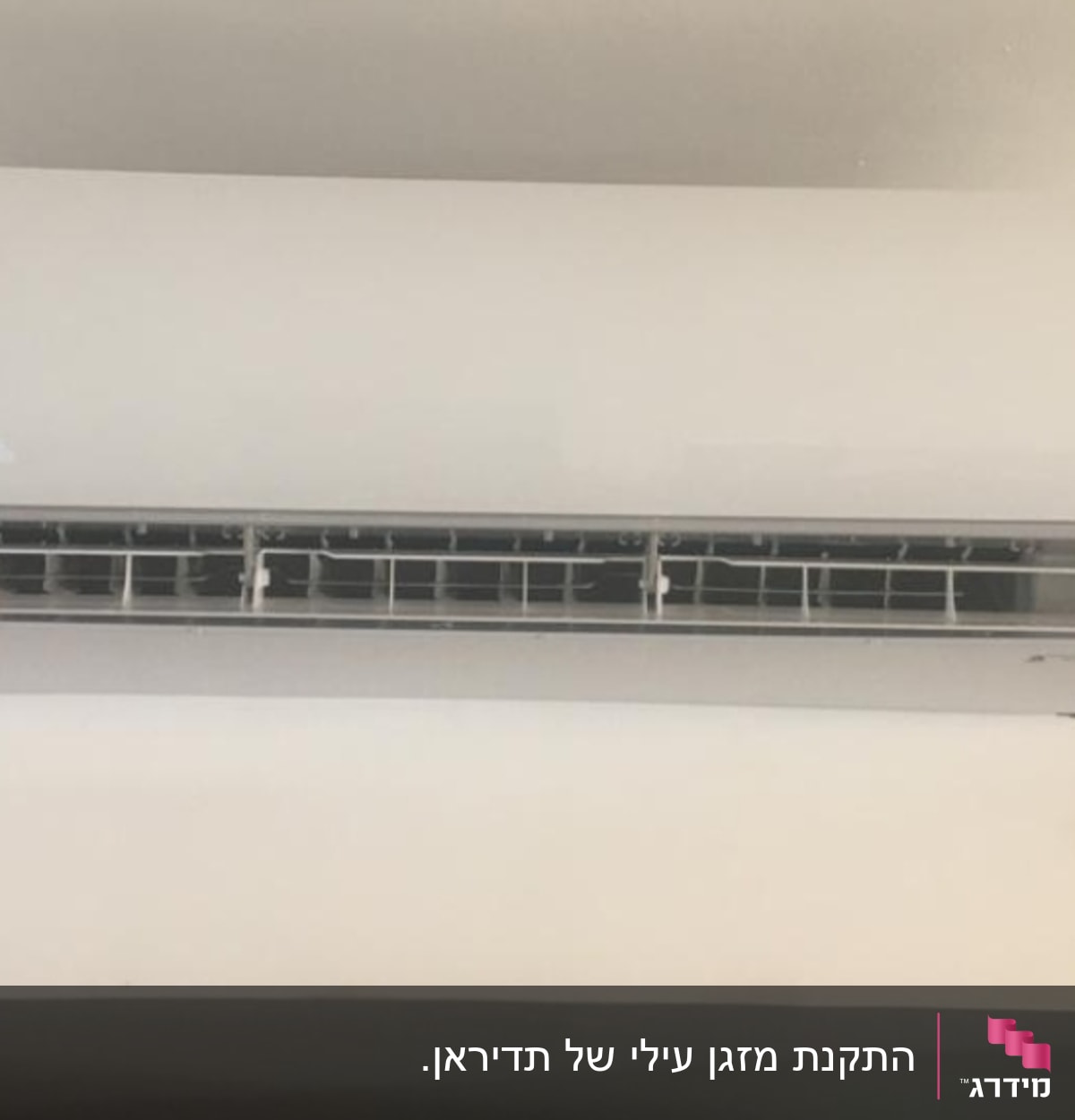 מזגן קיר לבן מותקן על קיר עם תצוגה דיגיטלית